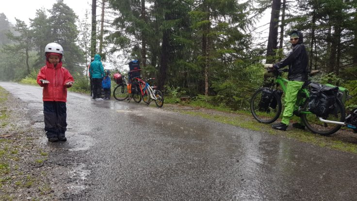 Kind, Familie mit Fahrrädern im Regen.