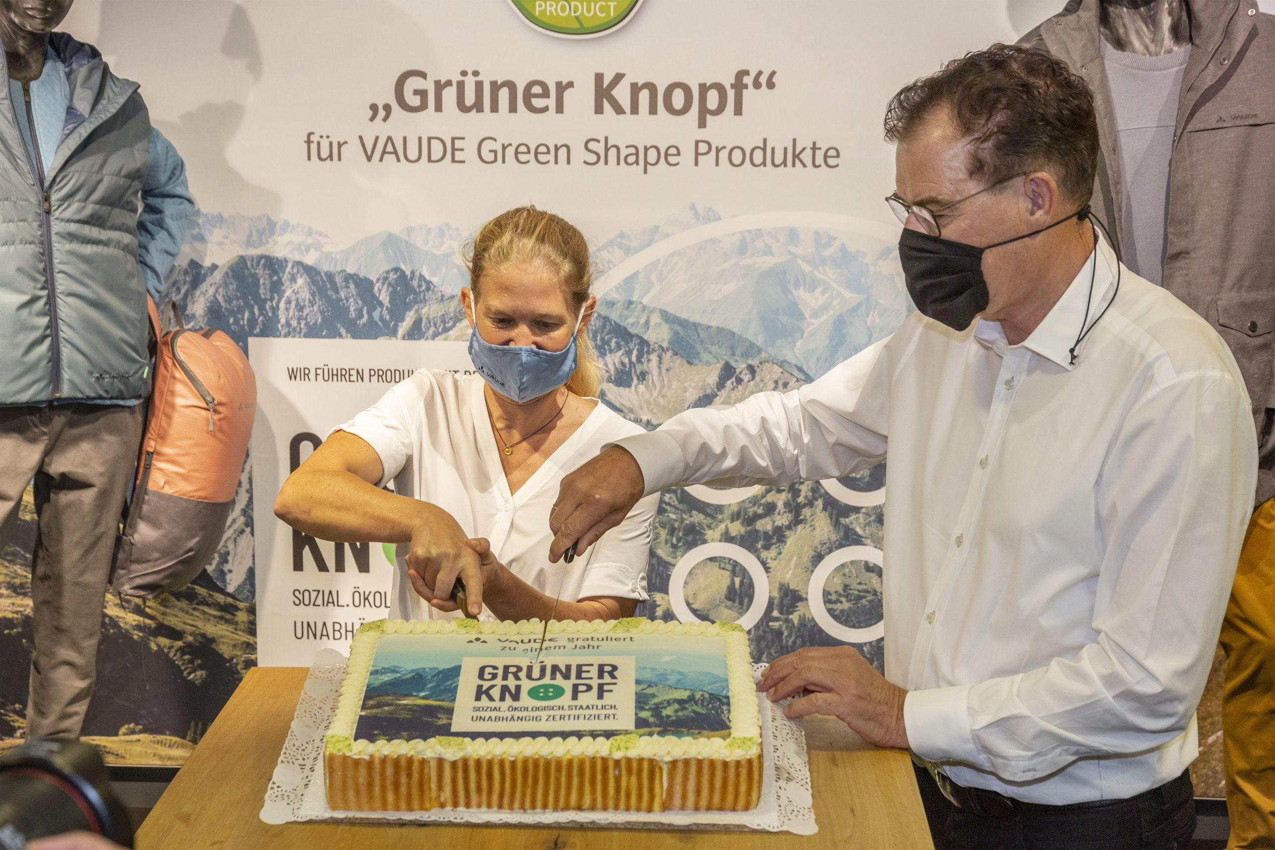 Antje von Dewitz und Gerd Müller schneiden die Geburtstagstorte für den Grünen Knopf an