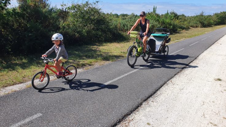 Kind auf Fahrrad, Familie auf Fahrrad mit Anhänger
