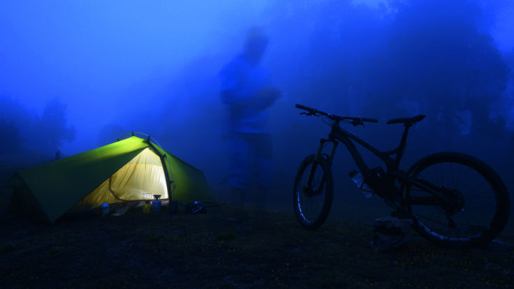 Zelt und Fahrrad in nebliger Dämmerung