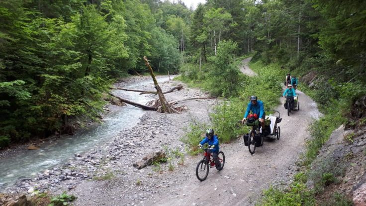 Familie, Radfahrer am Fluss im Wald.