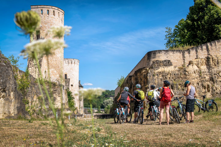 Gruppe Radfahrer besichtigt mittelalterlicher Stadtmauer.