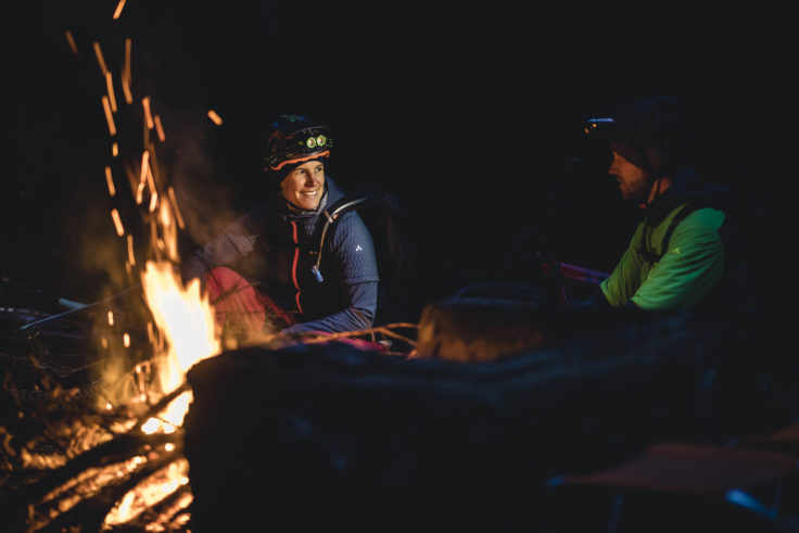 Zwei Mountainbiker sitzen am Lagerfeuer