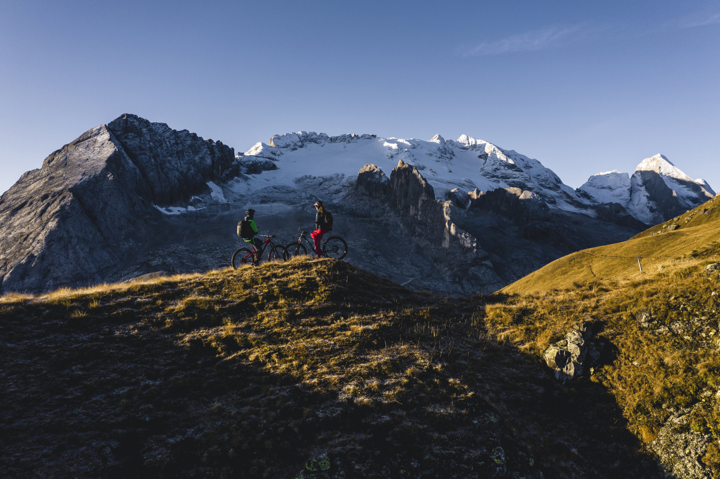 Mountainbiker vor schneebedeckten Bergen in den Dolomiten